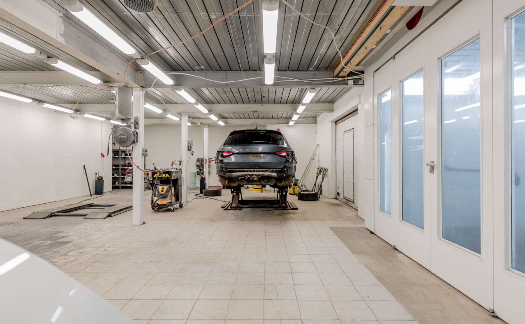Interiér autoservisu MCAR s automobilem na zvedáku